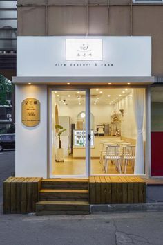 a store front with glass doors and wooden steps leading up to the outside door area