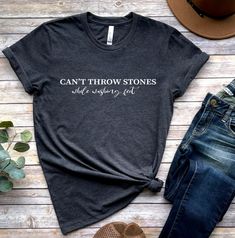 "\"Be the change you want to see in the world with our 'Can't Throw Stones While Washing Feet' shirt. A reminder that we should all be kind to one another, even when we disagree.\" 🕕Production Time 1-3 business day🕕 ➡️𝗛𝗢𝗪 𝗧𝗢 𝗢𝗥𝗗𝗘𝗥 ⬅️ 𝟏. Please, Check and Review all Photos. 𝟐. Select Your T-Shirt Size and T-Shirt Color from drop down menus. 𝟑. Enter your Design Color. 𝟒. Choose Your Quantity as much as you want. 𝟒. Click 𝗔𝗗𝗗 𝗧𝗢 𝗖𝗔𝗥𝗧. For multiple items go back to the lis Funny Cotton Tops With Quote Print, Inspirational Cotton T-shirt With Quote Print, Crew Neck Cotton Shirt With Quote Print, Cotton Crew Neck Shirt With Quote Print, Inspirational Crew Neck Top With Funny Text, Inspirational Cotton Tops With Quote Print, Inspirational Quote Print Cotton Top, Inspirational Short Sleeve Tops With Funny Text, Inspirational Cotton T-shirt With Funny Text