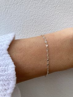 This super sparkly bracelet looks great stacked with other dainty bracelets! D E T A I L S  *925 sterling silver sequin chain measuring 1.8mm wide *A tiny sterling silver cross hangs from the end. *Hallmarked spring ring clasp.  S I Z I N G *  H E L P Choose the length from the drop down menu. Use the length guide as a reference. C A R E * T I P This is a dainty bracelet so please treat it with care. To maintain it in great condition avoid contact with water, perfume and harsh chemicals.Also remove when exercising, sleeping and doing housework in case it snags. Sterling silver can tarnish over time especially in humid conditions so always store in a dry place and if necessary clean with a jewellery cloth. P A C K A G I N G All our products are gift ready. T E R M S* O F* S A L E S & F A Q Minimalist Silver Jubilee Charm Bracelet, Sterling Silver Bracelet With Delicate Chain For Everyday, Delicate Sterling Silver Bracelets In Silver Color, Everyday Sterling Silver Bracelet With Delicate Chain, Delicate Chain Sterling Silver Bracelet For Everyday, Silver Beaded Bracelets With Delicate Chain, Dainty Silver Delicate Chain Bracelet, Silver Sterling Paperclip Bracelet With Adjustable Chain, Silver Sterling Minimalist Paperclip Bracelet