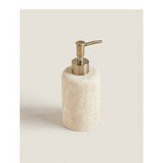 a white soap dispenser with a gold faucet on the top