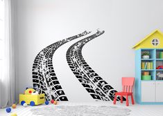 a child's room with a wall decal that has a tire track on it