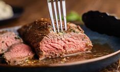 a fork sticking into some meat on a plate