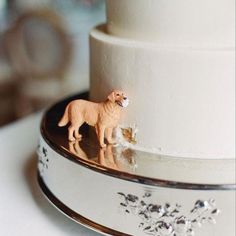 a close up of a wedding cake with a dog figurine on top