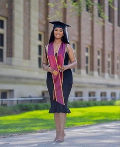 a woman in a graduation gown is walking down the street