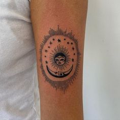 a person with a tattoo on their arm that has the sun and moon in it