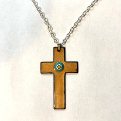 A timeless enameled copper cross, good for all ages. A layer of transparent golden glass enamel fired onto a copper cross at 1500˚F, allowing the natural sheen of the metal to shine through, with a glass millefiore stone in the center. The back side is enameled black. Cross is 2" x 1 1/4"  Choice of black or natural leather,  or cable chain. 16", 18" or 22"   Browse more Kickglass Enamels necklaces here https://www.etsy.com/shop/kickglassenamels?section_id=7232499 Shop home: kickglassenamels.ets Jewelry Cross Necklace, Necklace Christian, Jewelry Cross, Enameled Copper, Enamel Necklaces, Black Cross, Christian Jewelry, Enamels, Religious Jewelry