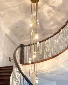 a chandelier hanging from the side of a spiral staircase