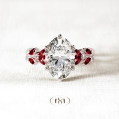 an oval shaped diamond ring with red accents