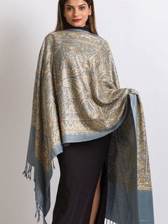 "Our Embroidered Shawl features fine embroidery on soft 100% merino wool. Specialty piece. This classically beautiful shawl showcases the intricate embroidery traditions of Northern India with stunning embroidery in silver metallic tones on a black base. Suitable for a black tie event, evening out, dinner party. Can change the look of last year's dress or pantsuit. A formal living room, drape over the back of the couch.  The high quality and elegance of our embroidered shawls make them treasures that will last for generations.  Color: Light Blue and Gold Price: $ 72.00 Size Dimensions: 78\" l x 28\" w Material: 100% Merino Wool, Gold silk threads Care: Dry clean only Global Origin: Made in India Ships free within the continental USA" Indian Shawl, Fine Embroidery, Embroidered Shawl, Paisley Shawl, Black Shawl, Fair Trade Clothing, Silver Silk, Embroidered Wool, Intricate Embroidery