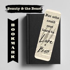 a bookmark with the words beauty and the beast on it next to an old book