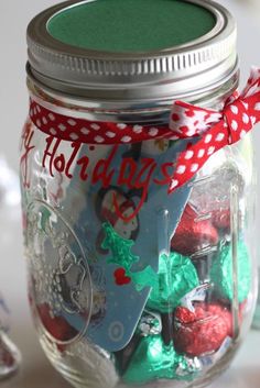 a glass jar filled with christmas candies on top of a table