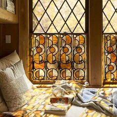 a bed sitting under two stained glass windows