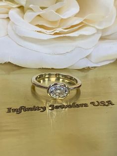 a close up of a ring on a table with a flower in the back ground