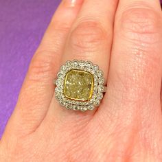 a woman's hand with a fancy yellow and white diamond ring on her finger