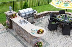 an outdoor kitchen and grill area with umbrella