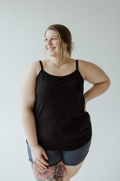 Introducing our Basic Layering Cami, the must-have piece for your wardrobe. Adjustable straps, scooped neckline, and tunic length make it perfect for layering under any outfit. With a slim fit and available in plus sizes, it's a versatile addition to any look. Don't just take our word for it, try it in every color! Fits true to size. We suggest going with your typical size. The cami is intended to be fitted. If you would like it to fit loose, we suggest going up one size. Leslie is wearing a siz Black Tank Top With Wide Adjustable Straps, Black Camisole With Built-in Bra For Layering, Everyday Black Tank Top With Adjustable Straps, Black Tank Top With Built-in Bra For Loungewear, Versatile Black Scoop Neck Top, Black Scoop Neck Tank Top With Built-in Bra, Black Tops With Adjustable Straps For Loungewear, Black Tops With Adjustable Straps And Stretch, Black Camisole With Adjustable Straps And Scoop Neck