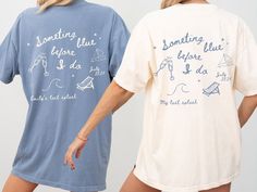 two women wearing matching shirts that say something blue and one has writing on the back