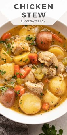 a white bowl filled with chicken stew and potatoes