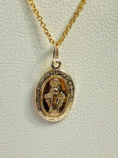 Virgin Mary Pendant, sku 1690 C Material : 14k Gold Handmade, Made in USA Price per pedant. Size: 8X13 mm, 0.25 x 0.50 in This listing is only for the pendant, not with the chain. We have many chains to choose from here... https://www.etsy.com/shop/AlohaPearlsHawaii?ref=simple-shop-header-name&listing_id=809788996&search_query=14k+chain We import Tahitian pearls straight from the crystal-clear lagoons of French Polynesia. Over the last 10 years of working with Tahitian pearl farmers and auction Stamped 14k Oval Link Jewelry As Gift, 14k Stamped Oval Link Jewelry As Gift, Sterling Silver Oval Pendant Jewelry Stamped 14k, Elegant Oval Miraculous Medal Jewelry, Sterling Silver Oval Pendant Stamped 14k, Elegant Round Miraculous Medal Jewelry, Yellow Gold Jewelry Stamped 14k With Oval Link, Tarnish Resistant 14k Gold Oval Pendant, Elegant Miraculous Medal Jewelry For Gift