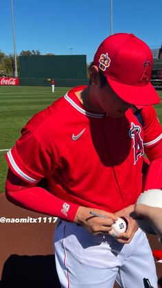 a baseball player holding a ball in his hand and wearing a red hat with the number 11 on it