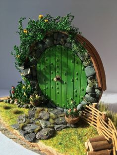 an image of a green door with plants growing out of it and some rocks on the ground