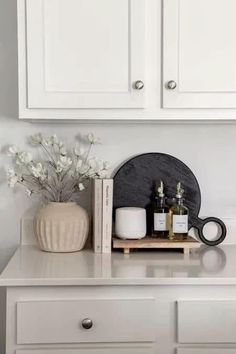 a white dresser with some bottles and candles on it