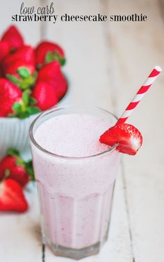 a strawberry milkshake with strawberries in the background