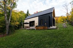 a small black house sitting on top of a lush green field