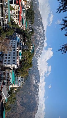 an aerial view of the ocean and houses on the cliff side, with blue skies in the background