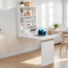 a laptop computer sitting on top of a white desk next to a book shelf filled with books