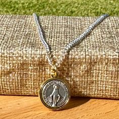 This Miraculous Medal necklace features a dainty two-toned design, with the border and ring of the medal finished in gold, while the central Miraculous Medal is a silver oxidized piece. Measuring ¾" in diameter, this medal is crafted in Italy, showcasing exceptional detail and a rich, three-dimensional silver-plated finish. The minimalist 16" chain adds elegance and makes it perfect for layering with other necklaces. This piece is lightweight yet sturdy, making it a great Catholic gift for her for any occasion--whether it's for a baptism, confirmation, or simply as a special token of faith. Want more than one? Message me for bulk discount pricing. For more pieces, visit kerrybestdesigns.etsy.com  My PROMISE to you: I am incredibly thankful for your choosing my designs. Of course, within 14 Adjustable Miraculous Medal For Gift, Miraculous Medal Jewelry Gift, White Gold Necklace With Miraculous Medal For Gift, White Gold Necklace With Miraculous Medal As Gift, Silver Engraved Necklace For First Communion, Engraved Silver Necklace For First Communion, Baptism Prayer, Miraculous Medal Necklace, Miraculous Medal