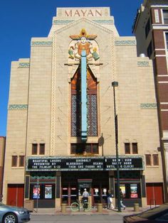 a tall building with a large cross on it's front and two cars parked in front