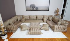 a living room filled with lots of furniture and an elephant painting on the wall behind it