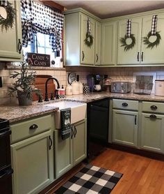 the kitchen is decorated for christmas with wreaths on the cabinets and dishwasher