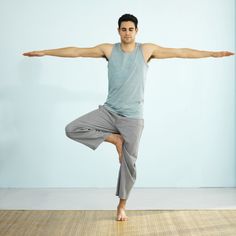 a man is doing a yoga pose with his arms stretched out and legs spread wide