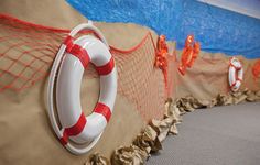 there is a life preserver on the wall next to some buoys and ropes