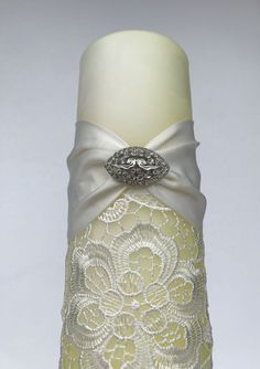 a white vase with a ring on it's side, decorated with lace and flowers