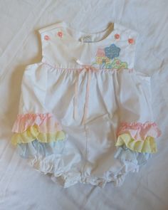 Cotton Bubble Romper With Ruffles For Playtime, Cotton Jumpsuits And Rompers With Ruffles, White Cotton Sweet Bubble Romper, Cute Ruffled Bubble Romper For Spring, Sweet White Cotton Bubble Romper, Playful Sleeveless Bubble Romper With Ruffles, Cute Ruffled Bubble Romper For Playtime, Playful Sleeveless Ruffle Bubble Romper, Playful White Jumpsuits And Rompers With Ruffles