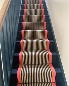 the stairs are lined with black and white striped carpet, along with pink and orange stripes