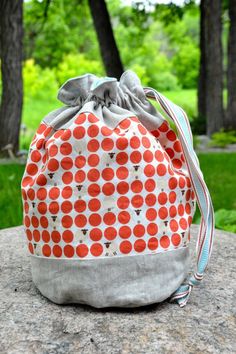 an orange and white bag sitting on top of a rock