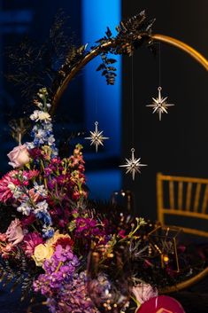 an arrangement of flowers and other decorations on a table with a chair in the background