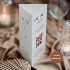 a close up of a book on a table with candles in the background and text that reads, table 1 side options