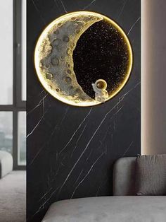 a living room with a couch and a wall hanging in the shape of a moon