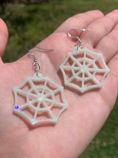 Each pair of earrings are handmade to order, therefore no two pairs are identical! However, I try to get as close as possible :) Made with sterling silver fishhooks (clear rubber backing included). Hypoallergenic & nickel free. Each spider web is approximately 1.5" x 1.5" and are made with epoxy resin, opaque white pigment, glow in the dark (white to neon green) pigment and white chunky holographic glitter ✨  Earrings are glow in the dark and UV blacklight reactive 🕸💚  Perfect for Halloween / White Spooky Earrings For Party, Spooky White Earrings For Party, White Drop Earrings For Halloween, Halloween Themed White Earrings, Handmade White Earrings For Halloween, White Dangle Jewelry For Halloween, Handmade Spooky Earrings For Gift, Handmade Novelty White Earrings, Hypoallergenic White Jewelry For Halloween