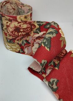 two rolls of red and green fabric with flowers on them sitting next to each other