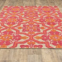 an orange and pink rug on a wooden floor