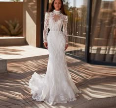 a woman in a wedding dress standing outside