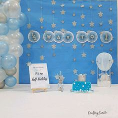 a blue and white dessert table with balloons