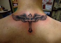 a man with a cross tattoo on his back and two birds sitting on the cross