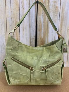 Dooney and Bourke medium size embossed croco Cinzia style leather shoulder bag in lime green This vintage Dooney and Bourke croco embossed leather shoulder bag in the Cinzia design is made of soft, supple leather.  This bag features two diagonal zippered pockets across the front with leather zipper pulls, a top magnetic zipper closure, side leather buckles, leather strap with Dooney and Bourke metal tag, and heavy silver swivel clips attaching the shoulder strap to the purse body, The lining is Green Leather Satchel With Crocodile Pattern, Green Leather Bag With Crocodile Pattern, Green Crocodile Pattern Satchel With Double Handle, Green Crocodile Pattern Satchel For Daily Use, Green Textured Leather Crossbody Satchel, Green Textured Leather Rectangular Shoulder Bag, Green Crocodile Pattern Shoulder Bag For Everyday Use, Green Rectangular Textured Leather Shoulder Bag, Green Crocodile Pattern Shoulder Satchel